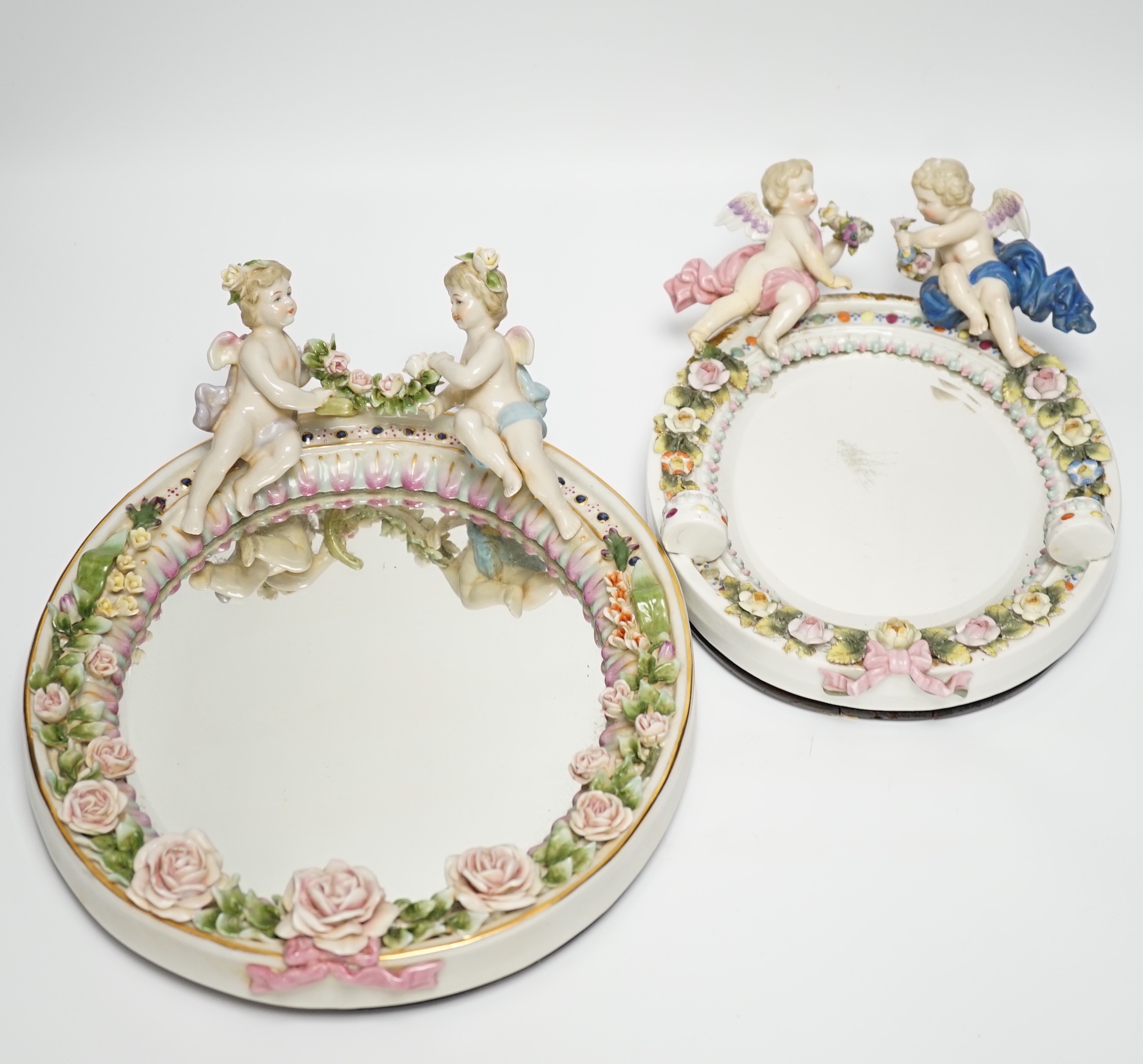 Two late 19th century German oval porcelain oval figurative mirrors, 33cm high